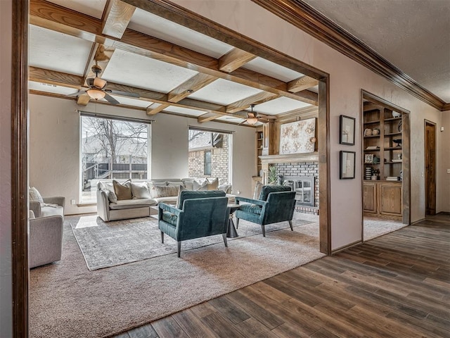 living room featuring dark wood-type flooring, coffered ceiling, beam ceiling, and a healthy amount of sunlight