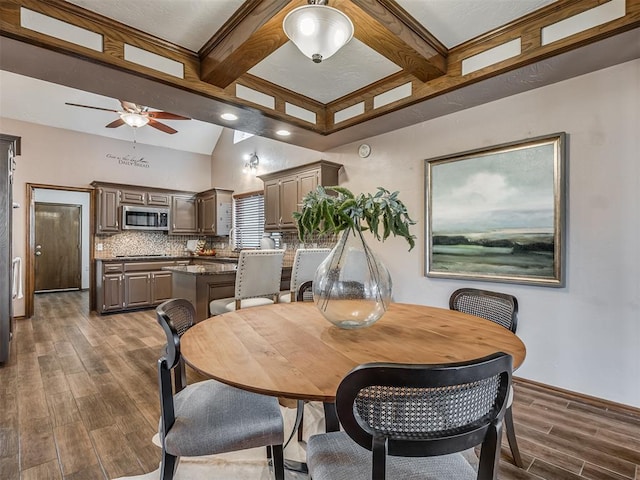 dining space featuring dark wood-style floors, beamed ceiling, and ceiling fan