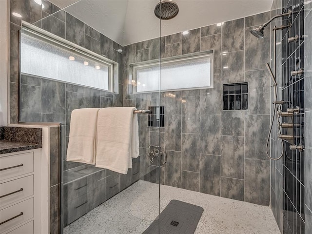 full bath with tiled shower and vanity