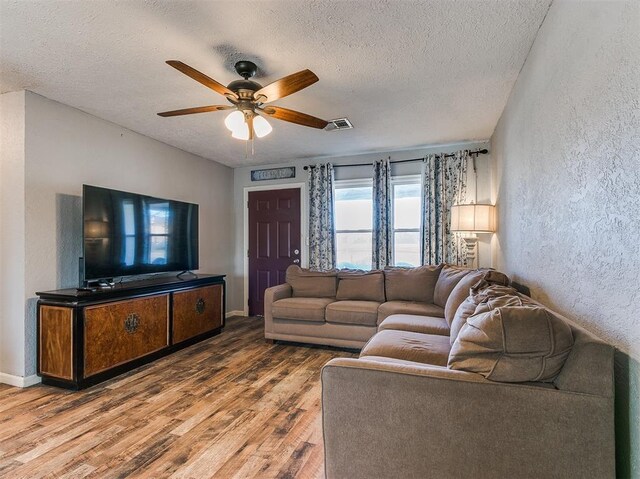 420 W Lincoln St, Purcell, OK 73080 - living area with visible vents, a ceiling fan, a textured wall, wood finished floors, and a textured ceiling