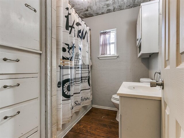 420 W Lincoln St, Purcell, OK 73080 - full bathroom featuring a textured wall, toilet, wood finished floors, vanity, and baseboards