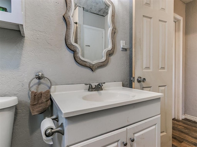 420 W Lincoln St, Purcell, OK 73080 - half bath featuring toilet, a textured wall, wood finished floors, and vanity