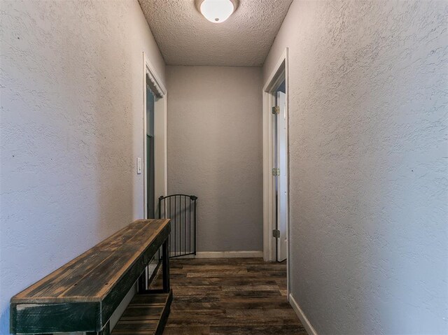 420 W Lincoln St, Purcell, OK 73080 - corridor featuring dark wood-style floors, a textured wall, a textured ceiling, and baseboards