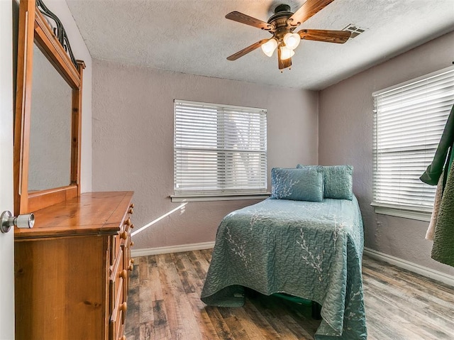 420 W Lincoln St, Purcell, OK 73080 - bedroom featuring a textured wall, wood finished floors, visible vents, and baseboards