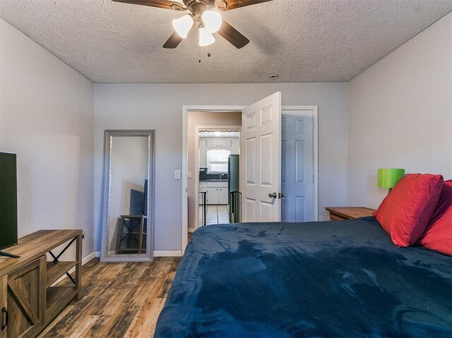 420 W Lincoln St, Purcell, OK 73080 - bedroom with a textured ceiling, refrigerator, a ceiling fan, baseboards, and dark wood finished floors
