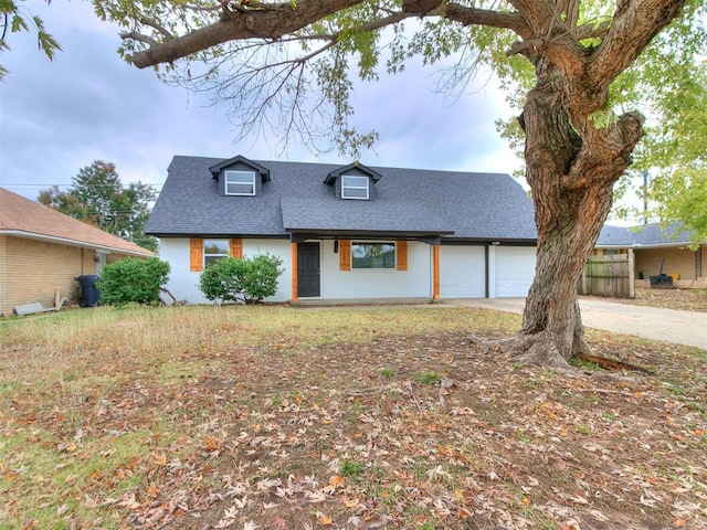 view of front of home with a garage, driveway, and a shingled roof