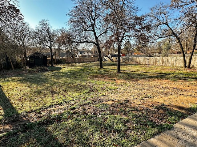 view of yard with a shed, fence, and an outdoor structure