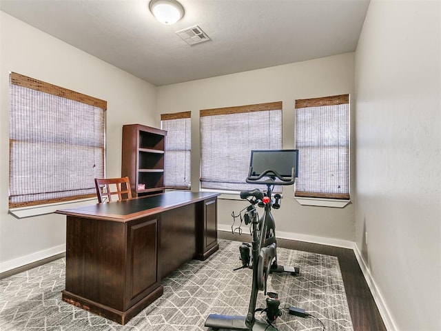 office space featuring a healthy amount of sunlight, visible vents, and baseboards