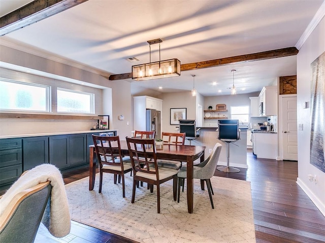 dining area with dark wood-style floors, beamed ceiling, and a healthy amount of sunlight