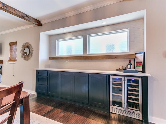 bar with wine cooler, a bar, crown molding, baseboards, and dark wood-style flooring