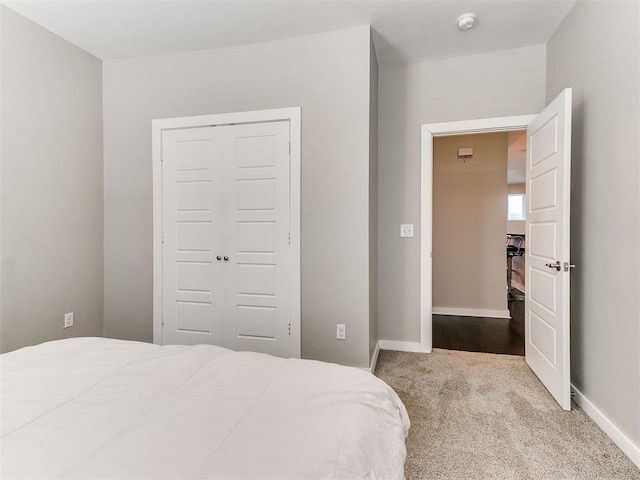 bedroom featuring carpet, baseboards, and a closet