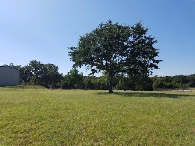 view of yard featuring fence and a rural view