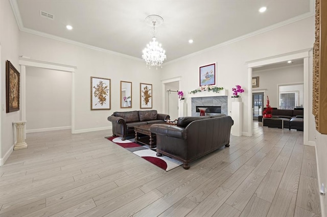 living room with ornamental molding, visible vents, a fireplace, and light wood finished floors