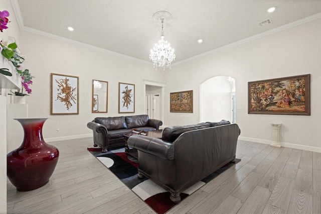 living area with arched walkways, light wood finished floors, baseboards, and crown molding