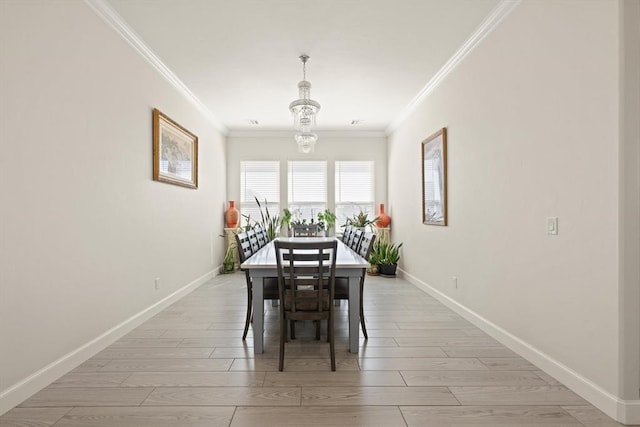 dining space with ornamental molding, baseboards, a notable chandelier, and light wood finished floors