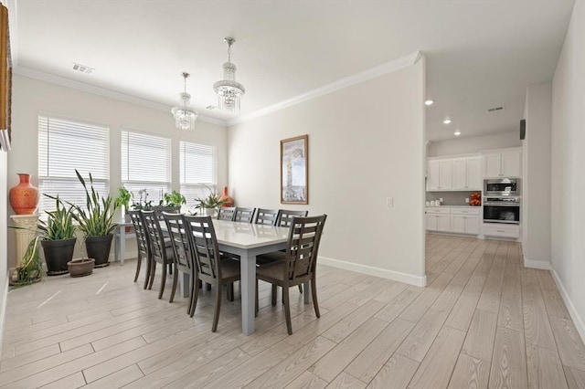 dining area with a notable chandelier, visible vents, ornamental molding, light wood-style floors, and baseboards