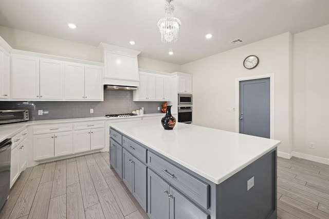 kitchen with white cabinets, stainless steel appliances, visible vents, and gray cabinets