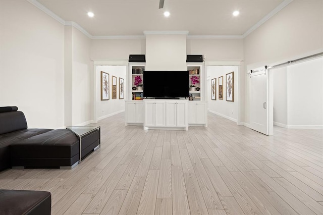 living area featuring light wood-type flooring, a barn door, baseboards, and crown molding