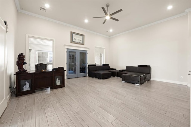 sitting room featuring a barn door, visible vents, ornamental molding, french doors, and light wood-style floors