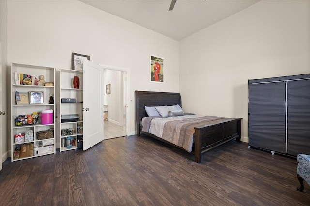 bedroom featuring a ceiling fan, lofted ceiling, baseboards, and wood finished floors