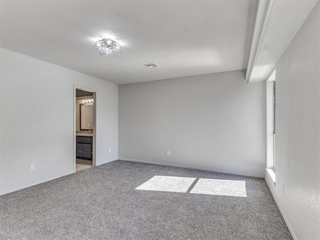 carpeted empty room featuring visible vents