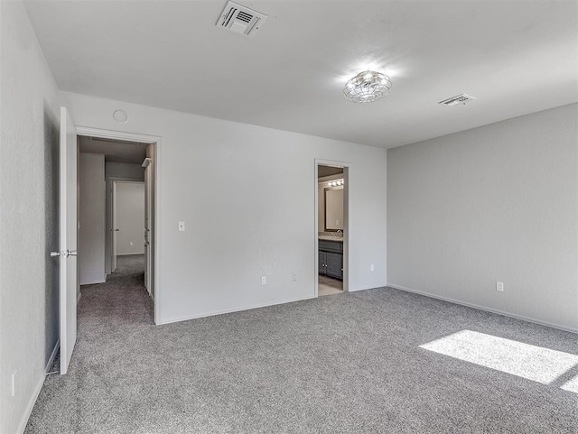 unfurnished bedroom featuring visible vents, carpet flooring, and ensuite bathroom