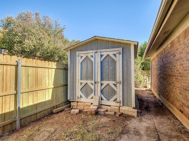 view of shed featuring fence