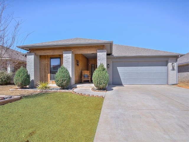 view of front of home featuring driveway, an attached garage, a front lawn, and a shingled roof