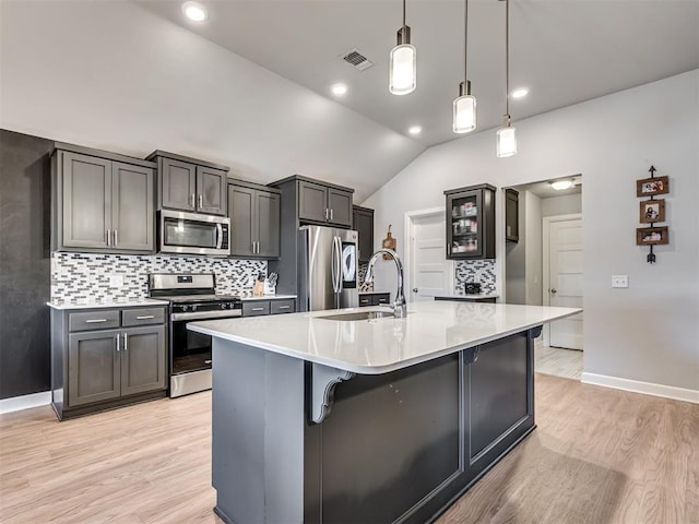 kitchen with lofted ceiling, light countertops, visible vents, appliances with stainless steel finishes, and a sink