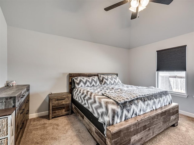 bedroom with a ceiling fan, light colored carpet, vaulted ceiling, and baseboards