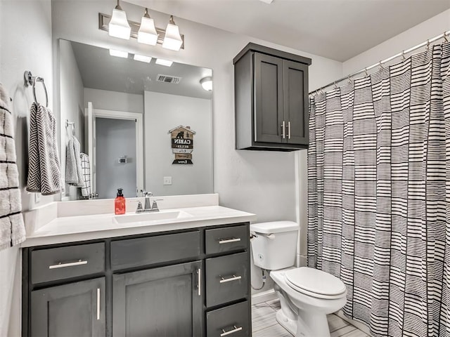 bathroom featuring toilet, vanity, and visible vents