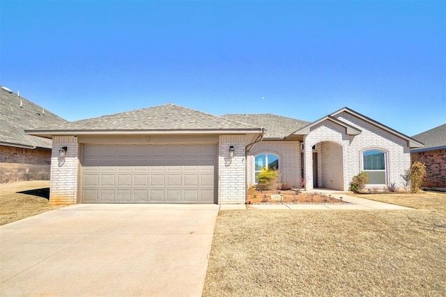 view of front of home with concrete driveway, brick siding, roof with shingles, and an attached garage