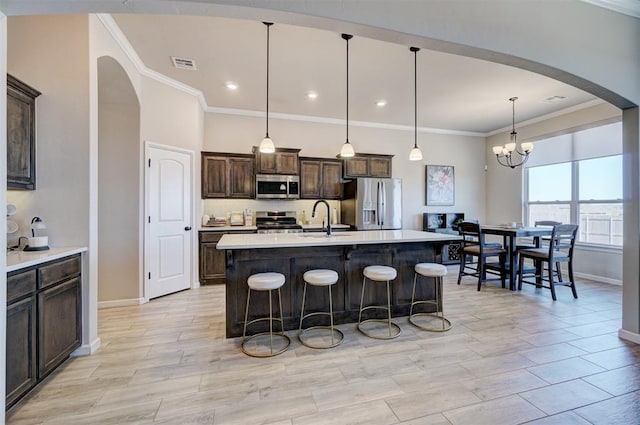 kitchen with visible vents, appliances with stainless steel finishes, light countertops, dark brown cabinets, and a sink