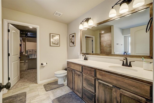 bathroom featuring visible vents, a sink, baseboards, and double vanity