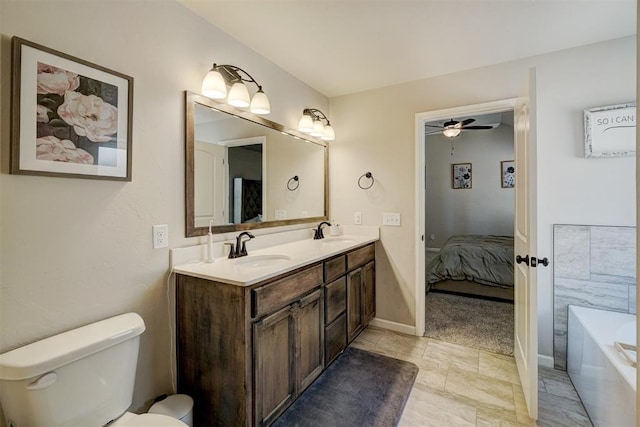 ensuite bathroom featuring a tub, a sink, toilet, and double vanity