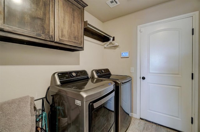 laundry area with cabinet space, baseboards, visible vents, and separate washer and dryer