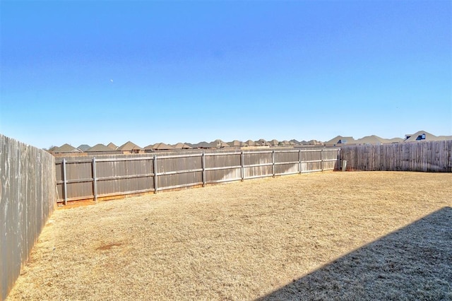 view of yard featuring a fenced backyard and a residential view