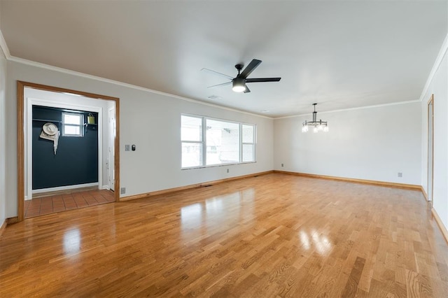 unfurnished living room with ceiling fan with notable chandelier, light wood-style floors, baseboards, and ornamental molding