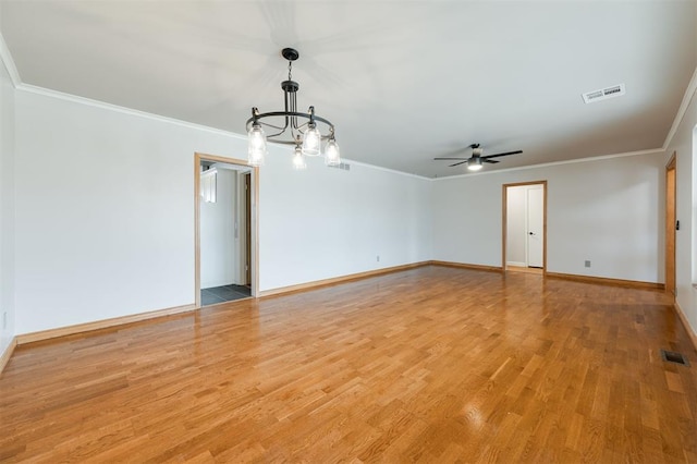 empty room with visible vents, baseboards, crown molding, and light wood finished floors