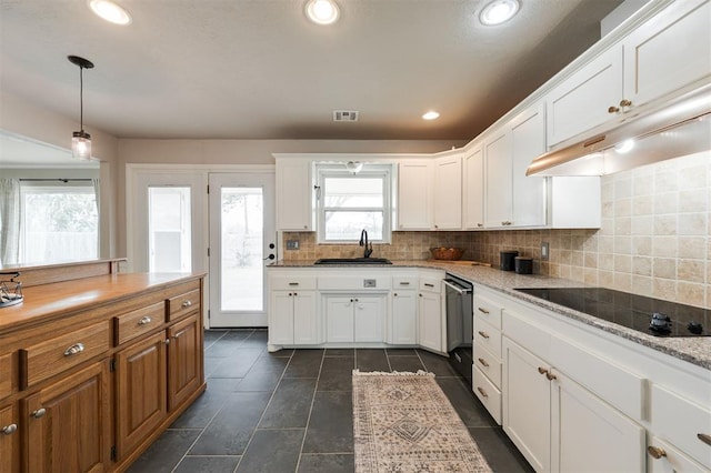 kitchen featuring dishwashing machine, visible vents, a sink, black electric stovetop, and tasteful backsplash