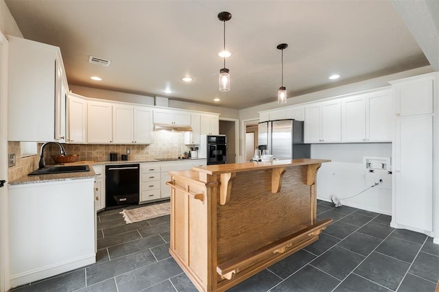 kitchen with a sink, backsplash, black appliances, and white cabinetry