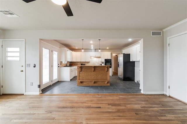 kitchen with white cabinets, visible vents, stainless steel refrigerator with ice dispenser, and dark wood-style flooring