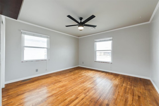 empty room with visible vents, baseboards, light wood-style floors, and ornamental molding