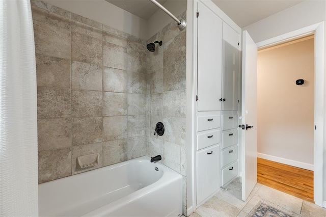 bathroom featuring baseboards and shower / tub combo