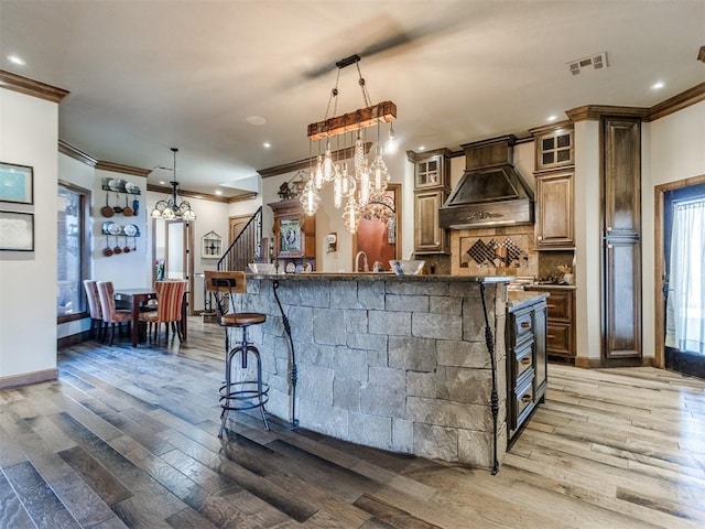 bar with wood finished floors, visible vents, stairs, custom exhaust hood, and tasteful backsplash