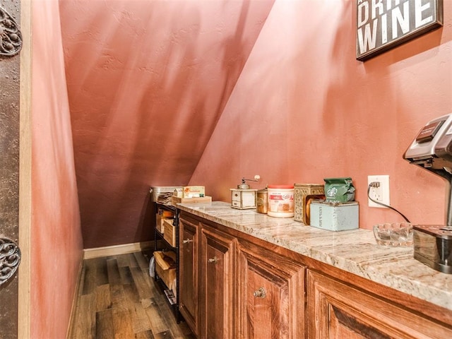 bathroom featuring lofted ceiling, baseboards, and wood finished floors