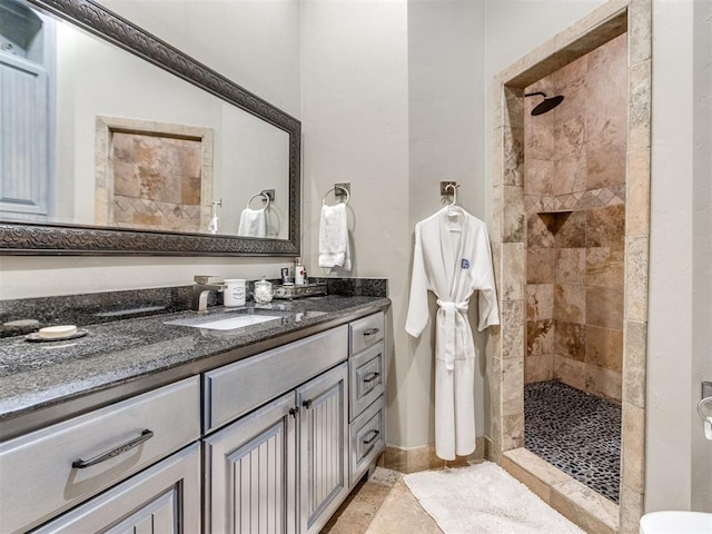 full bathroom with tiled shower and vanity