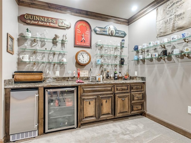 bar featuring light carpet, wine cooler, ornamental molding, stainless steel refrigerator, and indoor wet bar