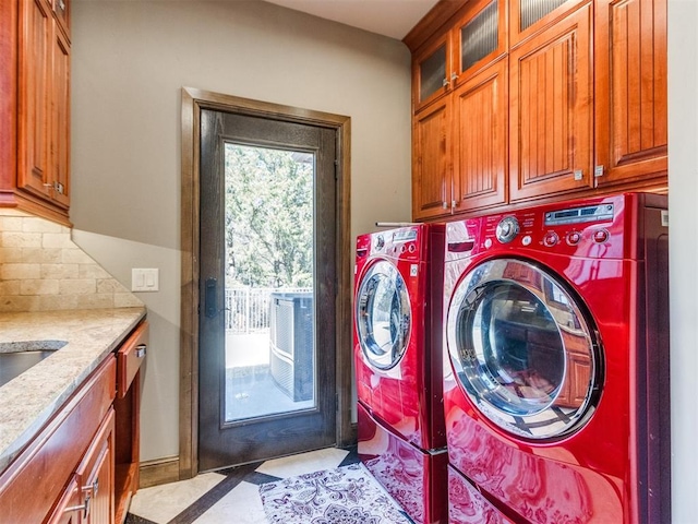 clothes washing area featuring cabinet space and washer and dryer