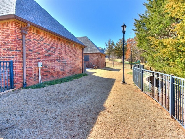 view of side of property with brick siding and fence